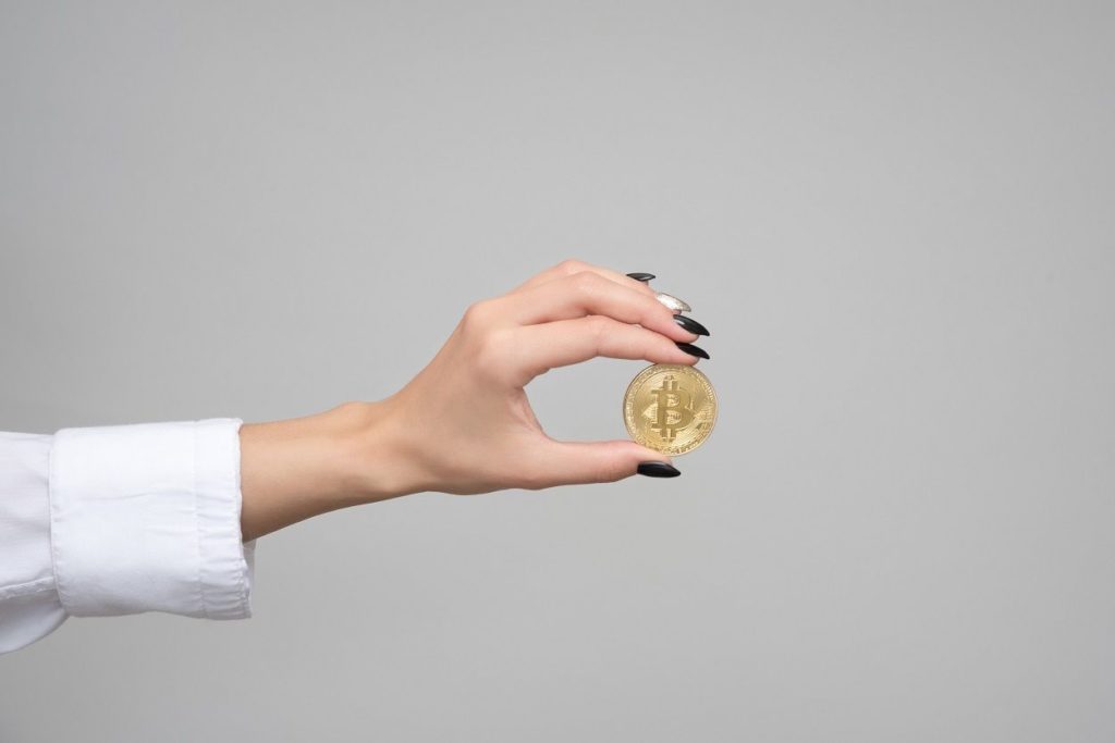 woman holding a bitcoin in her hand