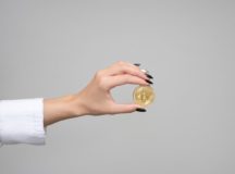 woman holding a bitcoin in her hand