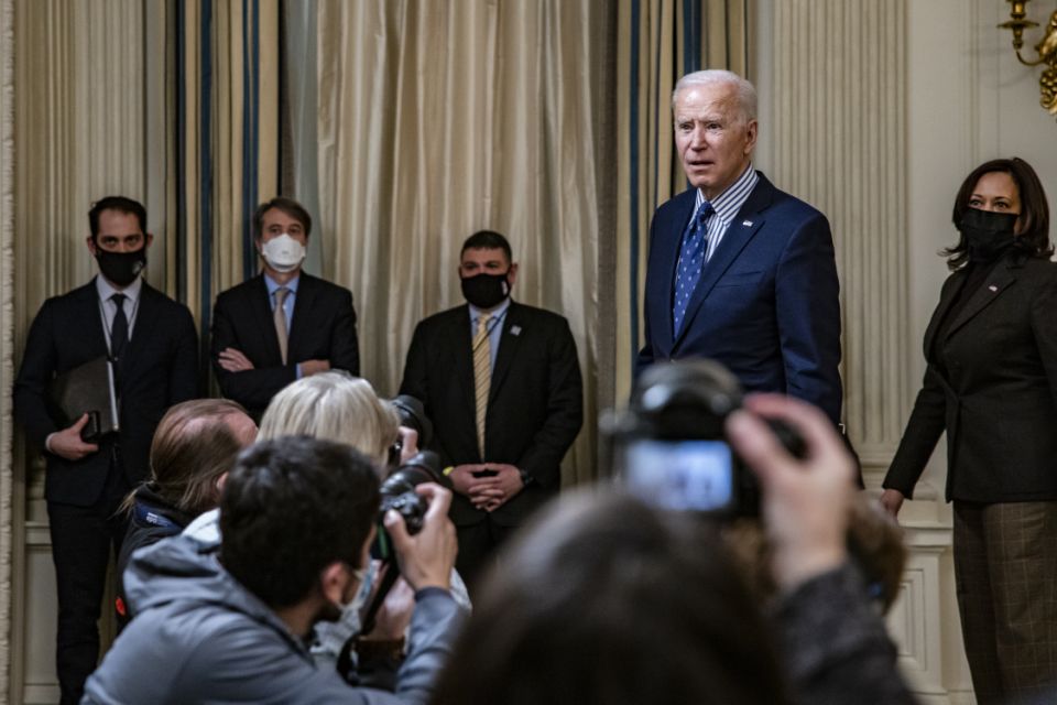 President Joe Biden, with Vice President Kamala Harris behind him, talkws with reporters at the White House on March 6, 2021. (Photo by Samuel Corum/Getty Images)